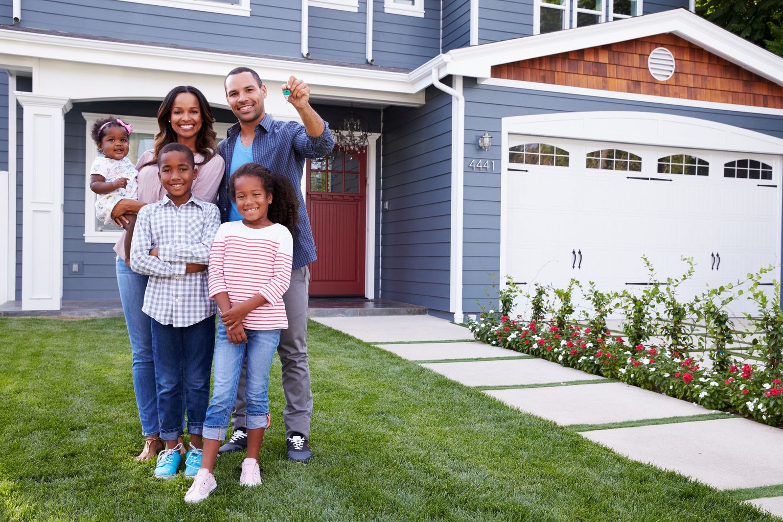 Happy homeowners standing in front of their house