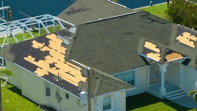 Aerial view of a house with shingles missing from wind damage